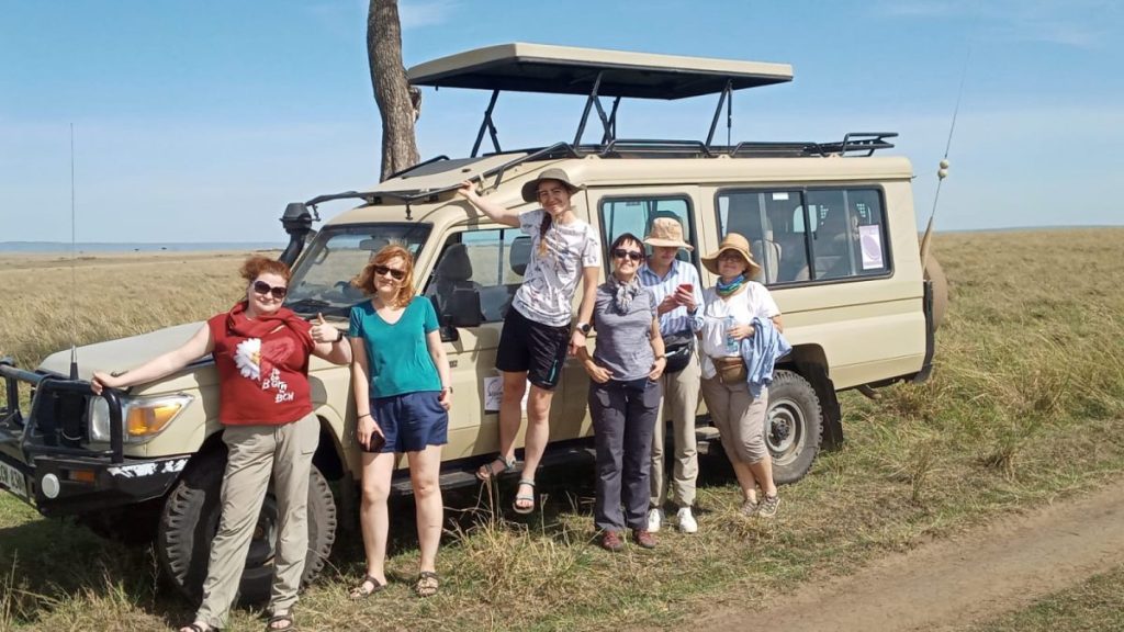 Tourists on a safari vehicle watching wildlife at a game drive in masai mara budget safari kenya Kenya Safari Holidays with Kairi Travels